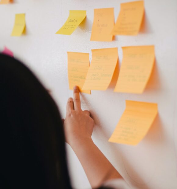 woman pointing at post-it notes